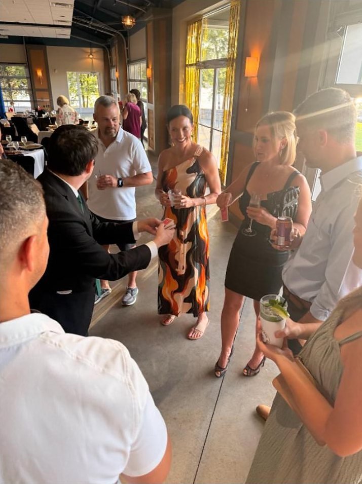 Josh Weidner performing close-up magic for a group of Cedar Creek Yacht Club members during cocktail hour.
