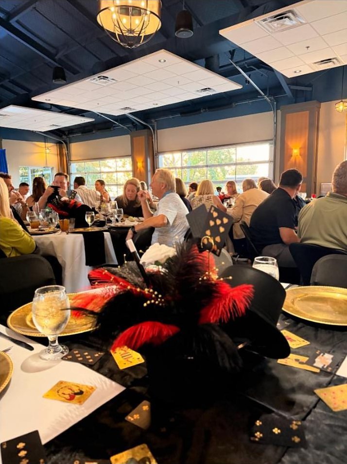 A table at the Cedar Creek Yacht Club Supper Club dressed with gold chargers, playing card place settings and red and black centerpieces.