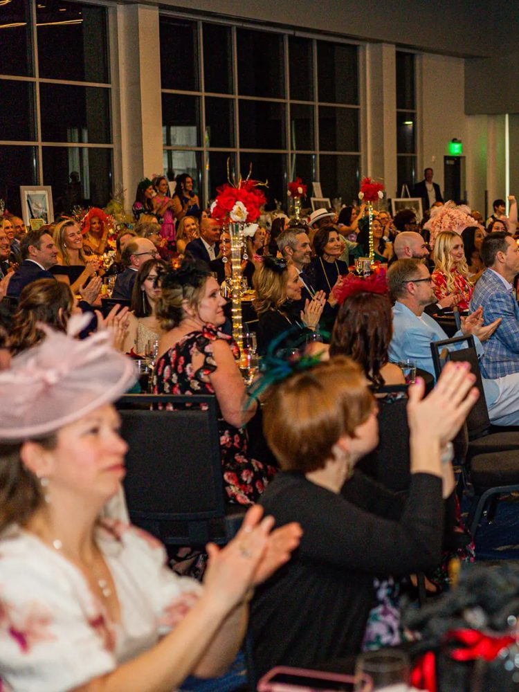 Guests in derby hats applauding from their tables during the GiGi's Playhouse Indy gala.