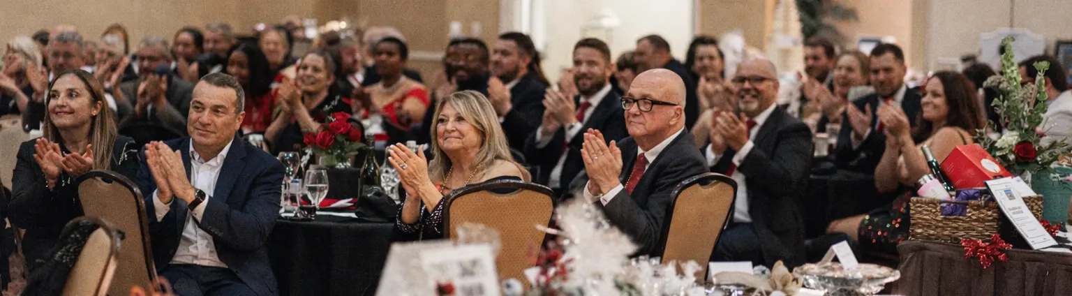 Guests applauding at a gala where corporate magician Josh Weidner hosted the program