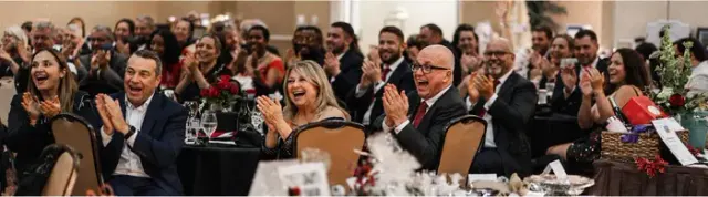 Guests laughing at their tables during a black-tie gala in St Louis