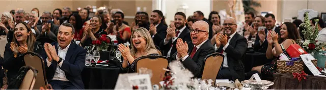 Guests laughing at their tables during a black-tie gala