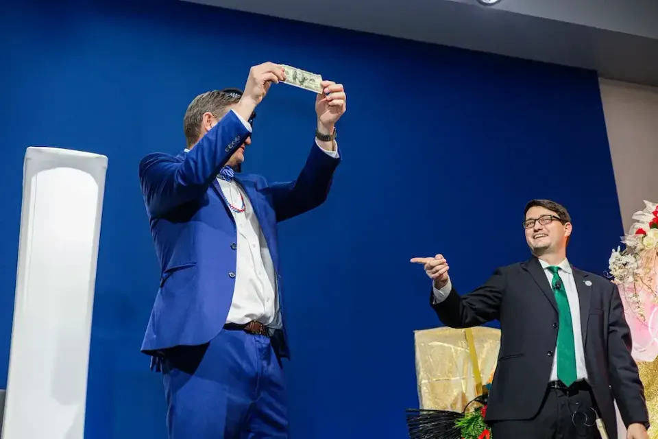 Holiday party magician Josh Weidner hosting a company party from the stage
