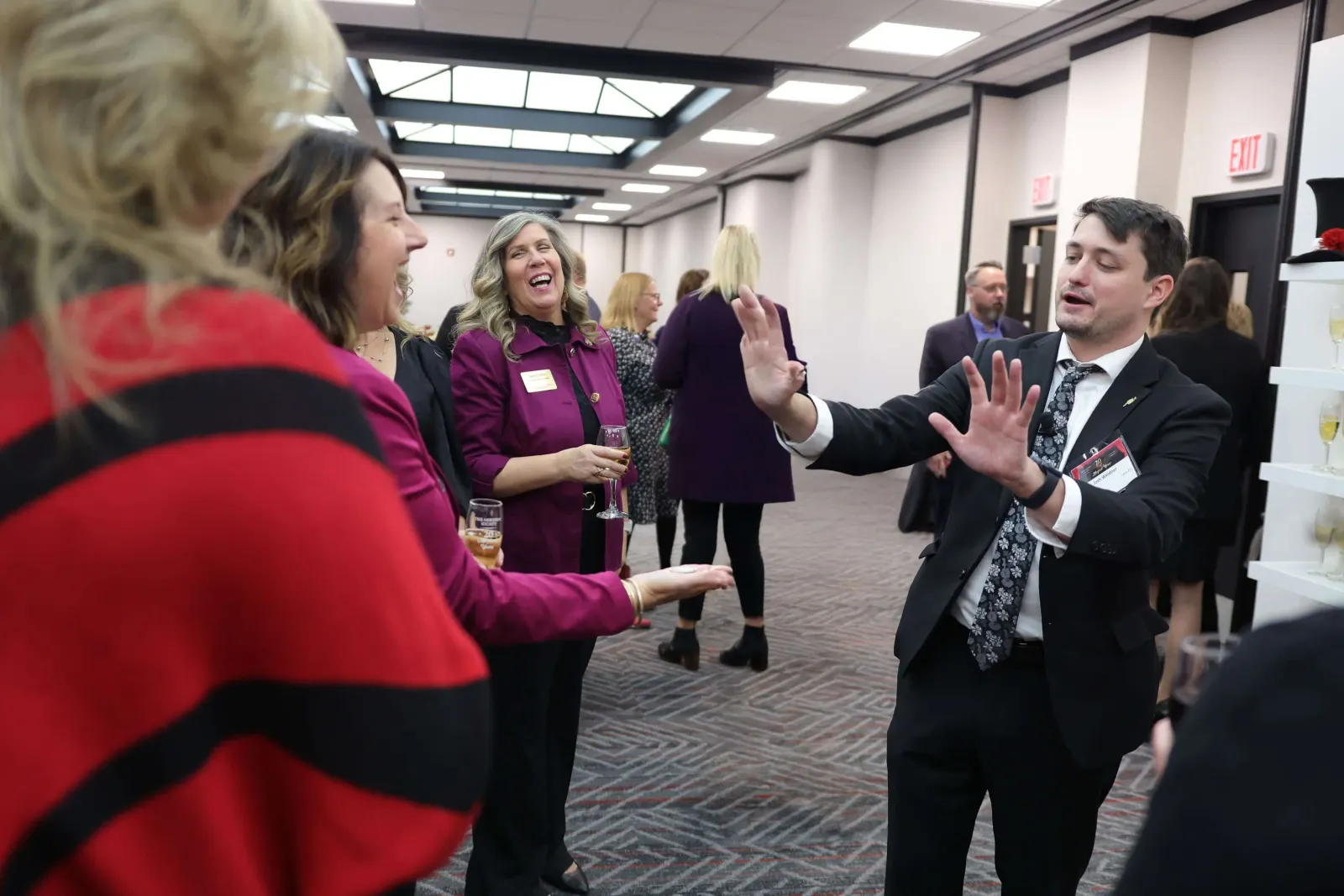 Guests laughing together during strolling magic by corporate magician Josh Weidner at a company reception