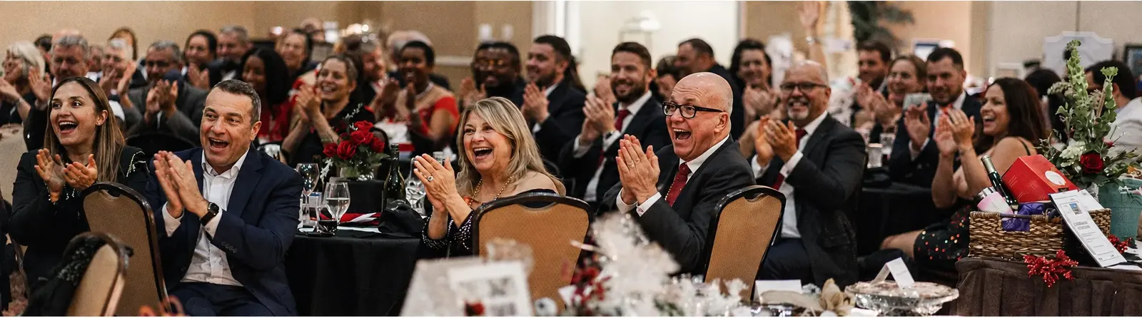 Wedding guests laughing during close-up magic by wedding magician Josh Weidner at a cocktail hour